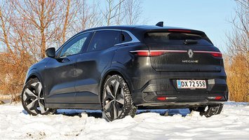 En sort Renault Megane set bagfra holder i sne med buske i baggrunden