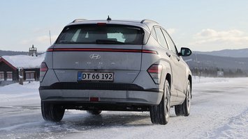 Hyundai Kona set bagfra, mens den holder på en snedækket vej