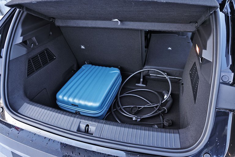Bagagerum med blå kuffert og ladekabler i en Renault Megane E-Tech