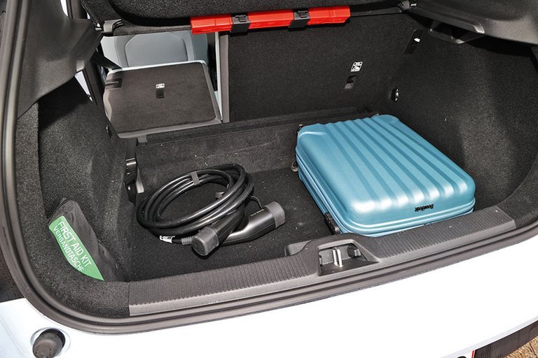 Bagagerummet i en Volvo EX30 med blå kuffert og ladekabel