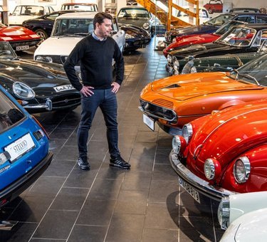 Mand i hal fyldt med klassiske biler