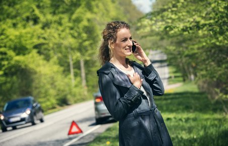 Kvinder taler i telefon, efter hendes bil er stoppet i rabatten.
