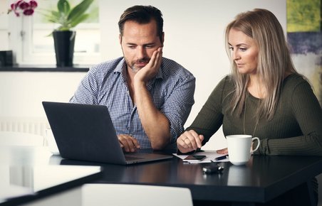 Mand og kvinde kigger sammen på bærbar computer.